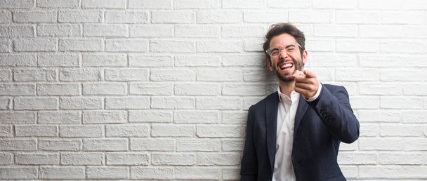 Молодой дружелюбный бизнесмен кричит, смеется и смеется над другим, концепцией насмешек и неконтроля
 - Фото, изображение