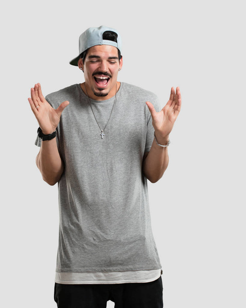 Young rapper man laughing and having fun, being relaxed and cheerful, feels confident and successful - Photo, image