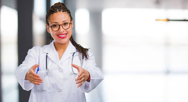 Ritratto di una giovane dottoressa nera che cerca di salutare qualcuno o fa gesti per aiutare, felice ed eccitata
 - Foto, immagini