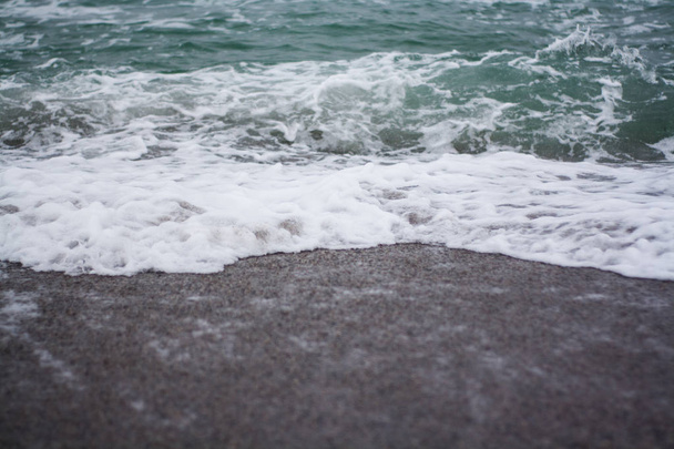 Pebbles on the beach, close up, sea waves on the background - Fotó, kép