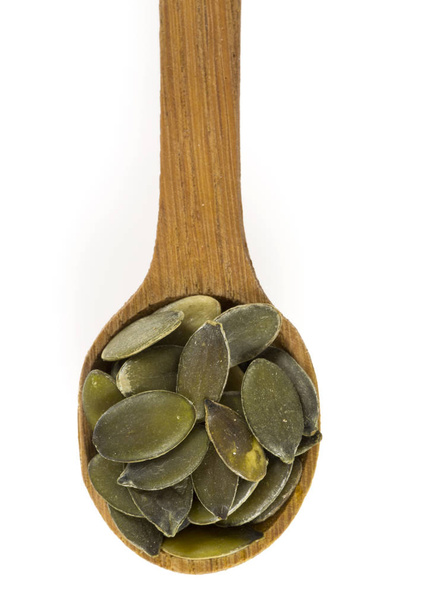 Raw pumpkin seeds in wooden spoon - Fotó, kép