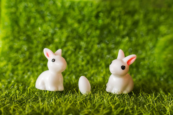 twee cijfers van een konijn en een ei op het gras. Gelukkig Pasen concept - Foto, afbeelding