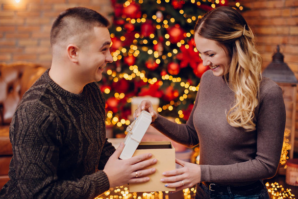 husband gives his wife christmas present at home - Zdjęcie, obraz