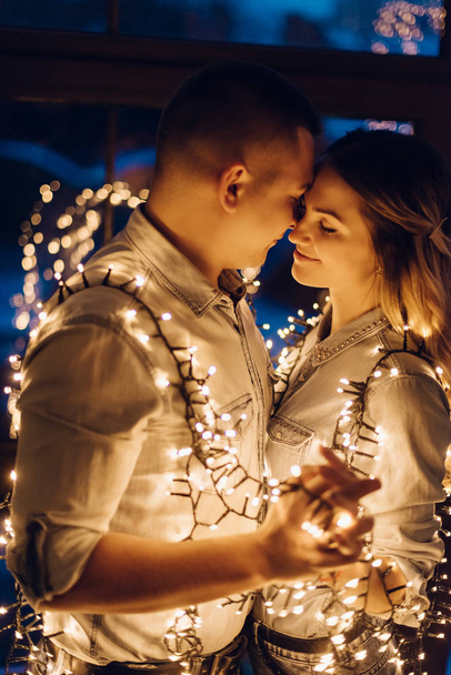 couple in love hugging in dark among multitude of lights - Photo, Image