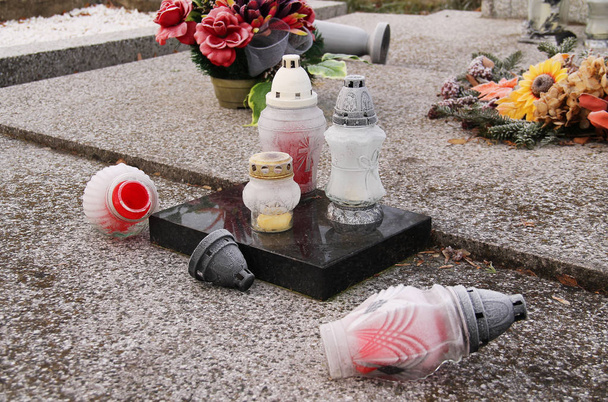 several lanterns on the grave, some of them fallen, covered with hoarfrost - Photo, Image