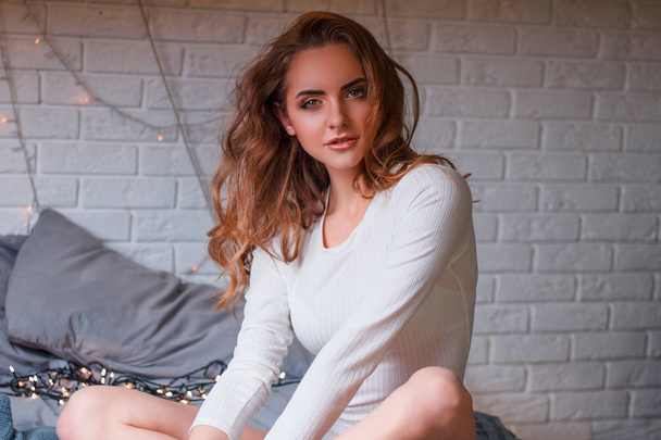 Retrato de cerca de una chica en un suéter blanco, sobre un fondo en el estudio
 - Foto, imagen