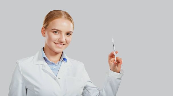 Woman doctor with a syringe in her hand on background.  - Fotoğraf, Görsel