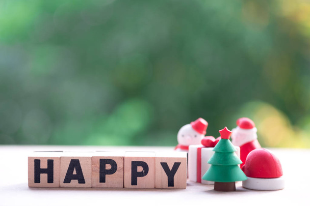 Рождественская елка рядом с деревянным блоком с "HAPPY" и природным фоном. Пространство для копирования текста или содержания. Озил счастлив
 - Фото, изображение