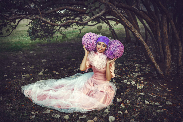 Φοράει ροζ φόρεμα το όμορφο μοντέλο ποζάρει σε μια δημιουργική περούκα  - Φωτογραφία, εικόνα