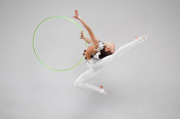 The teenager girl doing gymnastics exercises isolated on white background - Фото, зображення