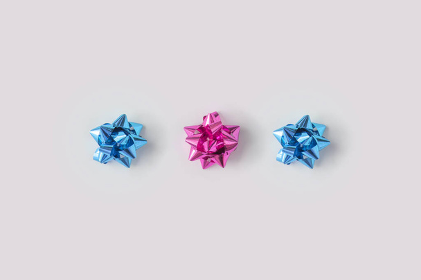 ряд пластиковых розовый и синий декоративные рождественские банты подарок, новогодняя концепция
 - Фото, изображение