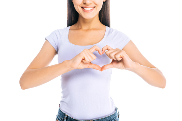 обрізаний знімок усміхненої жінки, що показує знак серця ізольовано на білому
 - Фото, зображення