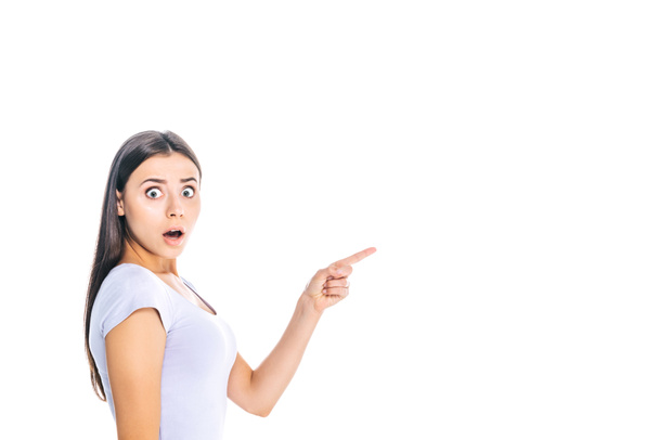 side view of shocked young woman pointing away isolated on white - Foto, Bild