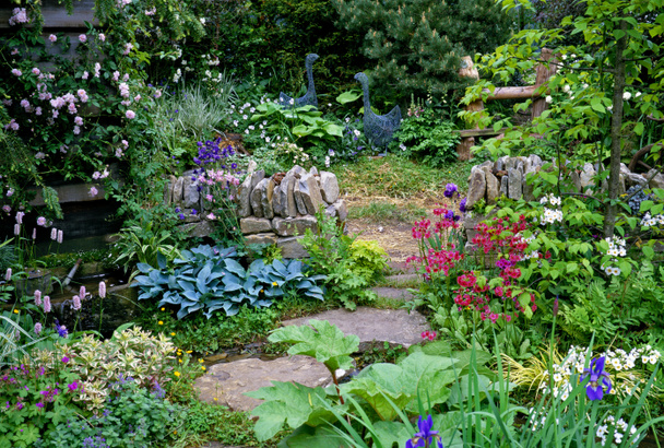 A cottage garden with mixed planting and a drystone wall - Photo, Image