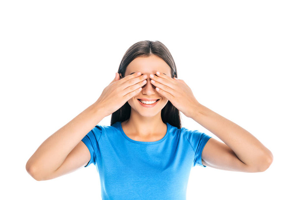 obscured view of cheerful woman covering eyes with hands isolated on white - Foto, Bild