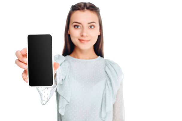 portrait of smiling woman showing smartphone with blank screen isolated on white - Foto, afbeelding