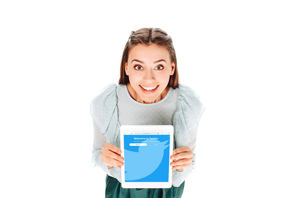 high angle view of cheerful woman with tablet with twitter logo on screen isolated on white - Foto, immagini