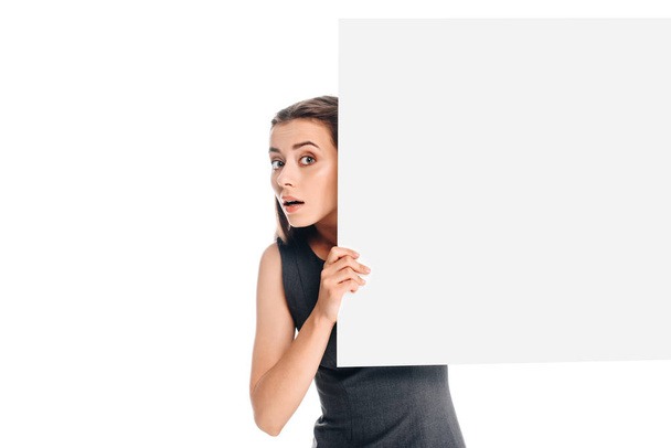 portrait of shocked young woman with blank banner isolated on white - Fotó, kép