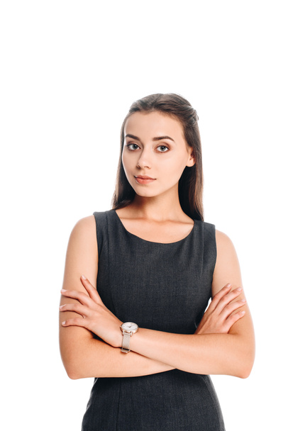 portrait of young woman in black dress with arms crossed isolated on white - Foto, afbeelding