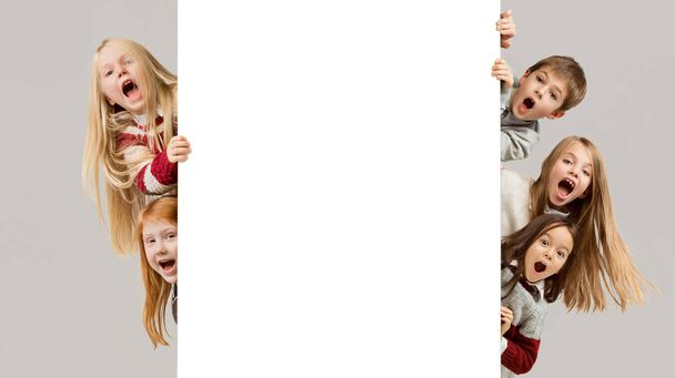 Banner with a surprised children peeking at the edge - Photo, Image