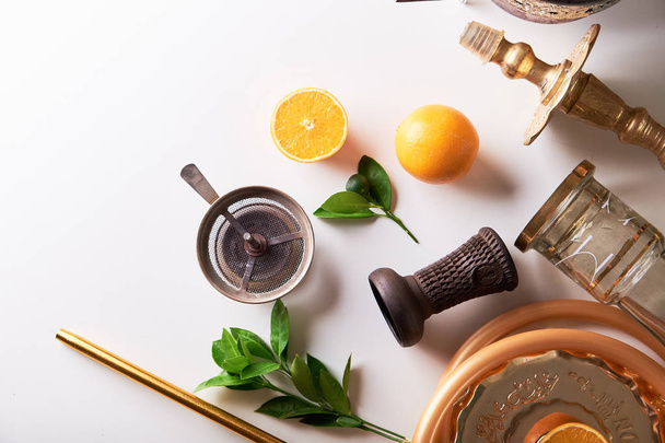 Shisha hookah details with orange and green leaves on white background. Copy space. - 写真・画像