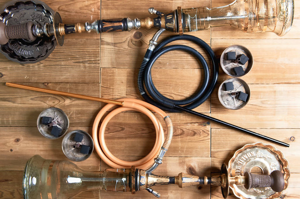 Top view of shisha details on wooden background. Hookah, pipes and coal. - 写真・画像