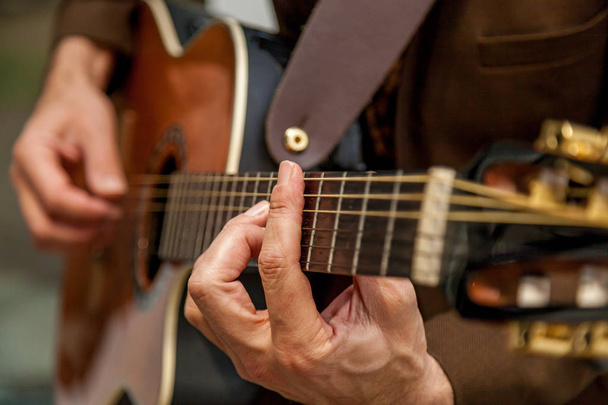 Close-up das mãos de um músico tocando guitarra. Os dedos do músico estão pressionando as cordas na guitarra. Músico tocando baixo - Foto, Imagem