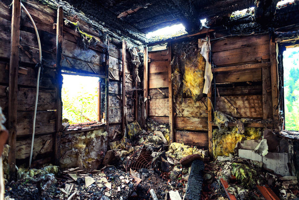 Сгоревший дом с обугленной крышей и обгоревшей мебелью
 - Фото, изображение