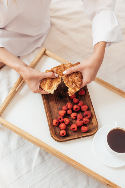 levágott kép nő tépte fel croissant néző tálca az időszakban reggel otthon - Fotó, kép