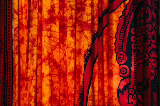 Tecido vermelho dobrado com ornamentos indianos
 - Foto, Imagem