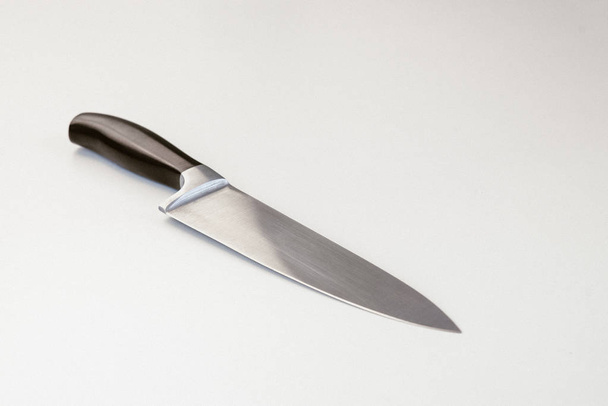 Μεγάλο μαχαίρι κουζίνας που βρίσκεται στο τραπέζι στο στούντιο - Φωτογραφία, εικόνα