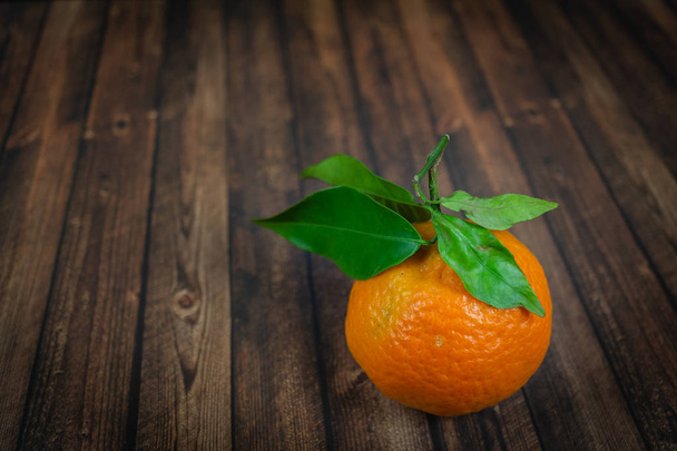 Mandarin with green leaves on wood background - Foto, imagen