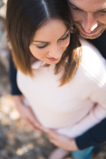 Young couple expecting baby, smiling and hugging her tummy. - Foto, Bild