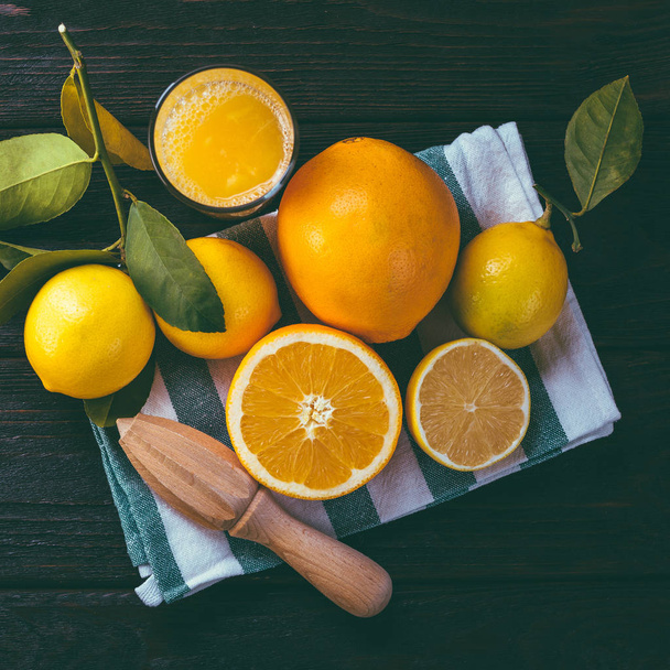 SAP van citrusvruchten, donkere houten achtergrond, juicer - Foto, afbeelding