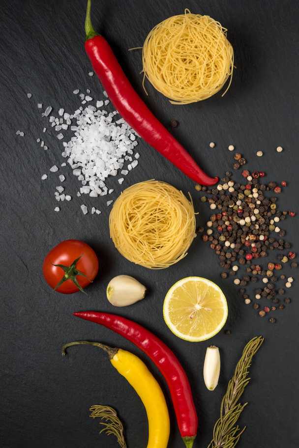 Noodles with colorful vegetables and spices on black background. Food concept. - Fotoğraf, Görsel