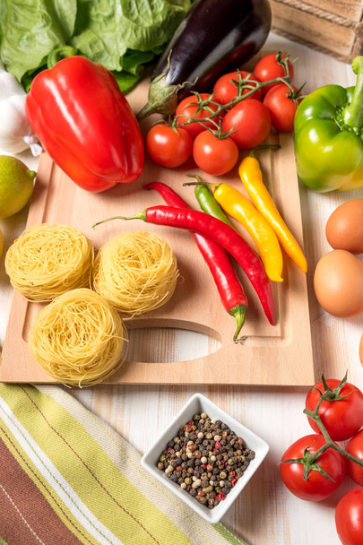Colorful vegetables and noodles on wooden background. Food concept. - Фото, зображення