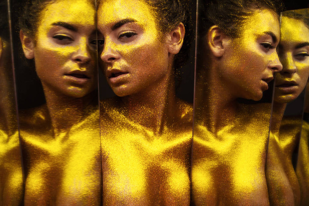 sexy girl gold-plated glittering posing - Zdjęcie, obraz