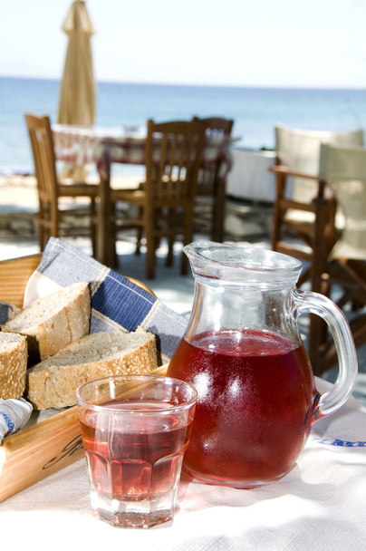 ギリシャの島のタヴェルナで家庭の作られたバラ ワインと無愛想なパン - 写真・画像