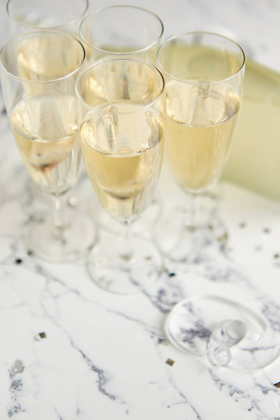 Champagne glasses and bottle placed on white marble background - Φωτογραφία, εικόνα