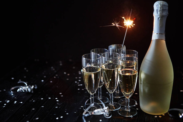 Party composition image. Glasses filled with champagne placed on black table - Photo, Image