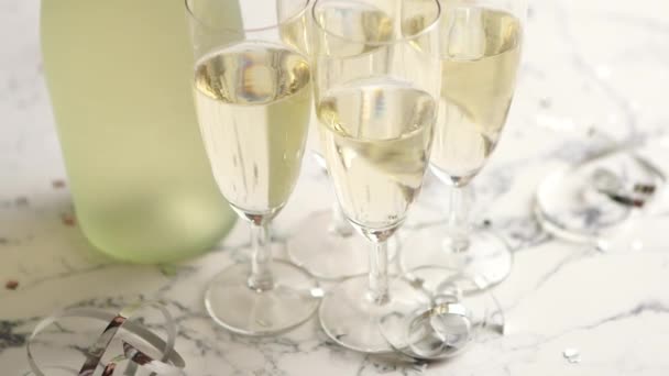 Бокалы для шампанского и бутылка на фоне белого мрамора - Кадры, видео