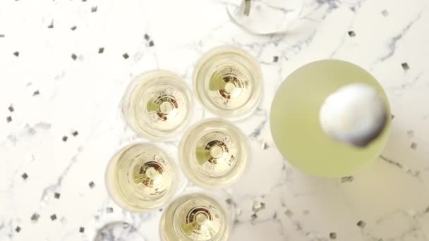 Copas de champán y botella colocadas sobre fondo de mármol blanco - Metraje, vídeo