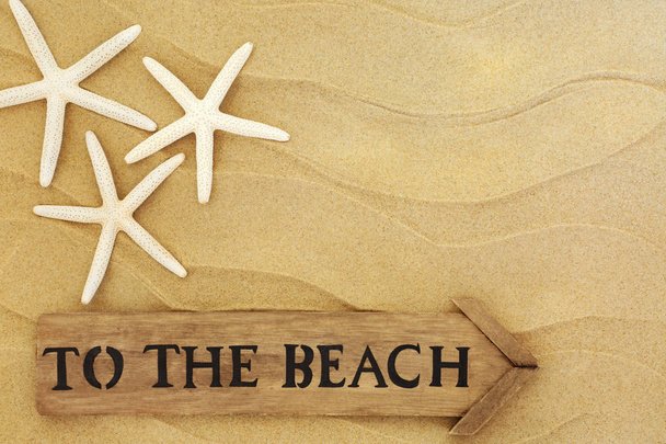 Summer holiday concept with old rustic to the beach sign and starfish on sand. - Photo, Image