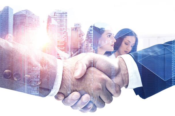 Close up of two business people shaking hands with double exposure of managers brainstorming and modern city with triangular pattern. Toned image - Foto, Bild