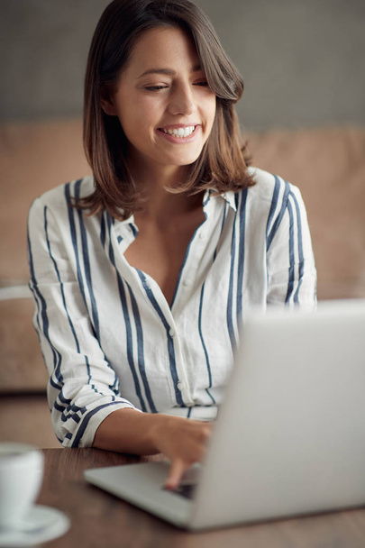Portrait of smiling woman working from home on laptop - Businesswoman working - Zdjęcie, obraz