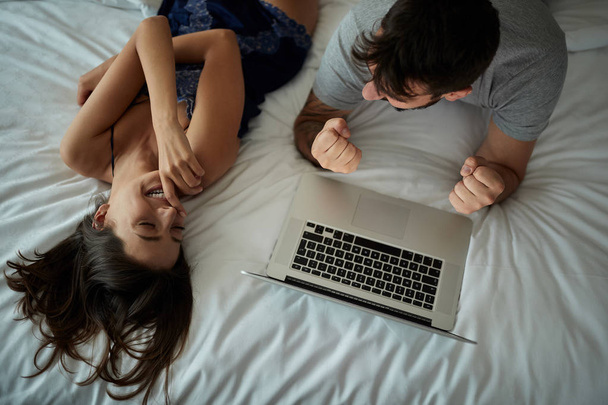top view of Funny young couple with laptop in the bed - Фото, зображення