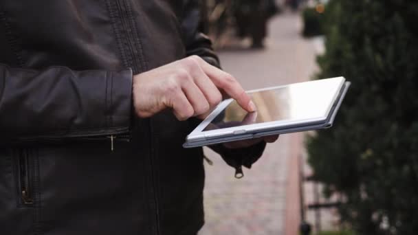 Detail mans ruce použití tabletového počítače venkovní, člověk dělá online nákupy, procházení Internetu - Záběry, video