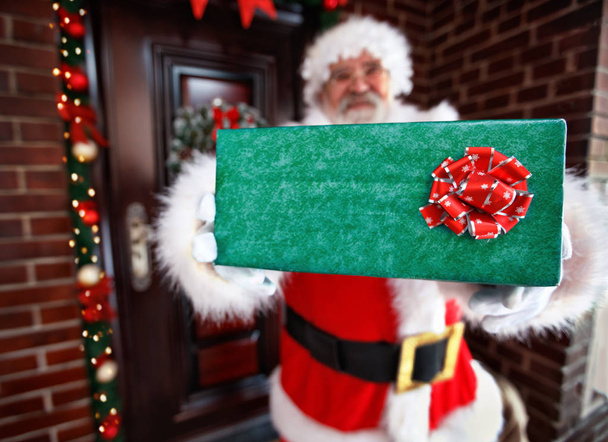 Santa Claus holding Christmas present - Zdjęcie, obraz