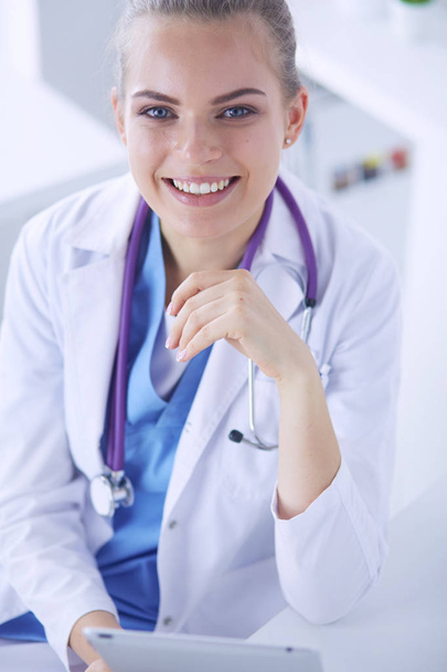 Close-up Portret van vriendelijke vrouwelijke arts met stethoscoop en tablet in handen. - Foto, afbeelding