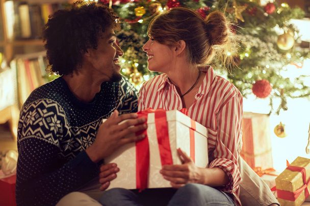 Romantic male and female exchanging Christmas presents and enjoying in holiday - Valokuva, kuva